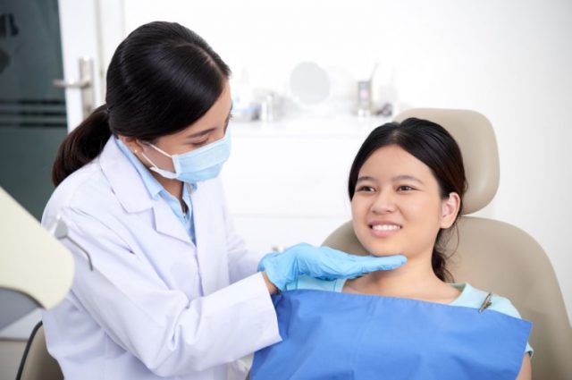 Dentist checks on patient