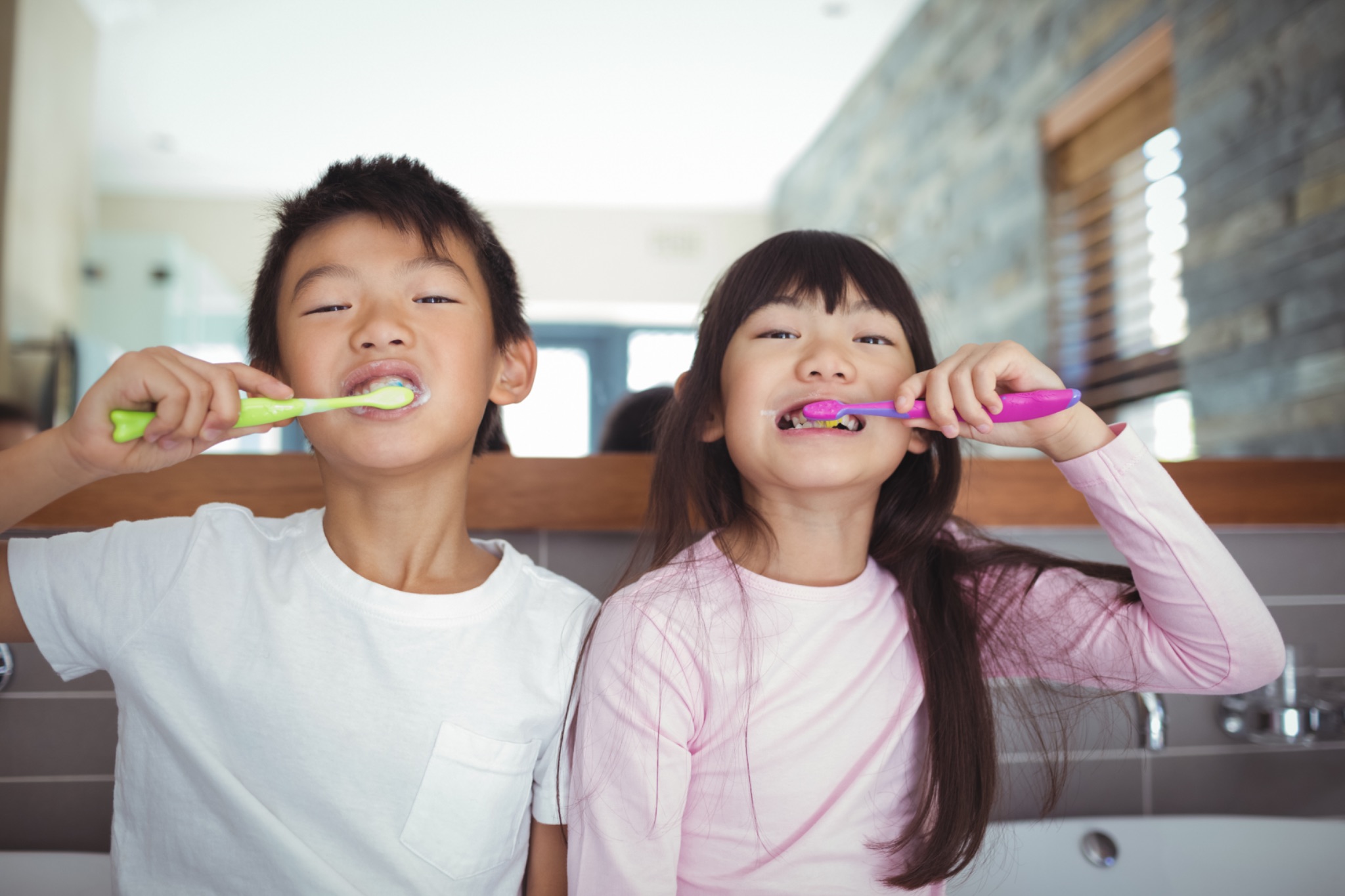 siblings brushing teeth.